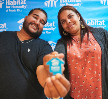 Pareja con fondo azul y llave a su hogar, gracias  Habitat for Humanity