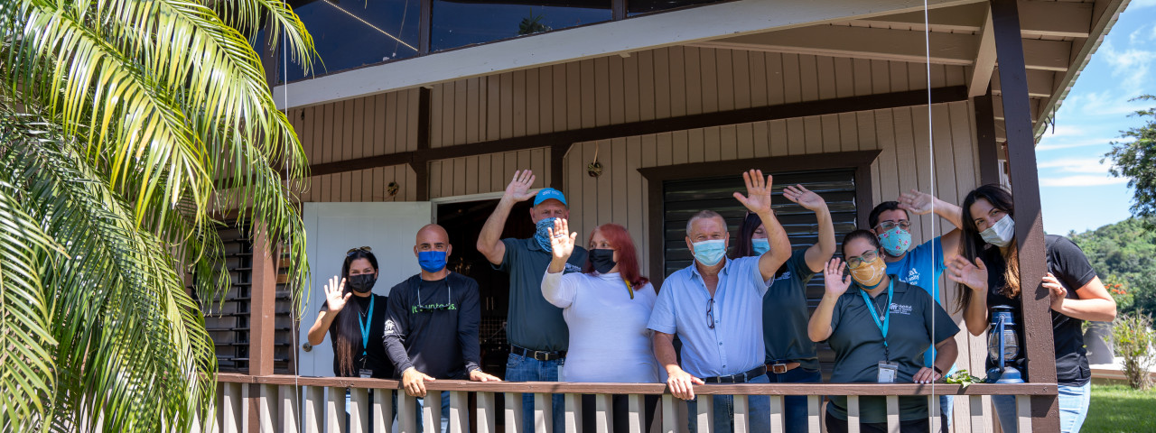  A group of people wave from the balcony, after a day of volunteering and celebration