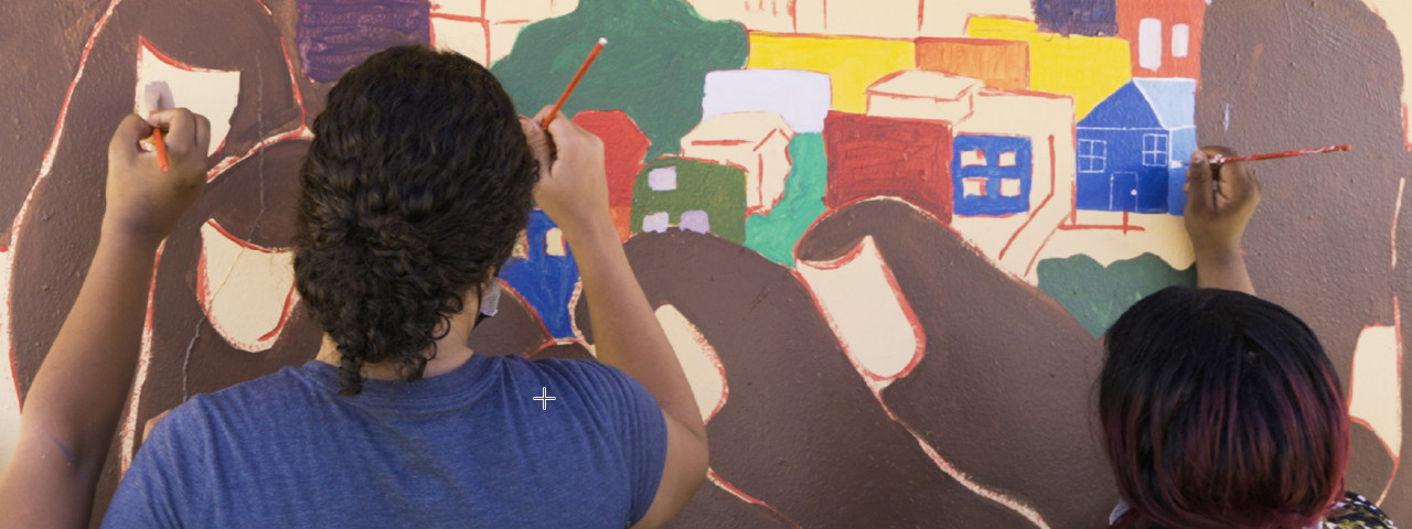 Participantes del Programa de Capacitación Comunitaria comparten sus historias en un mural.